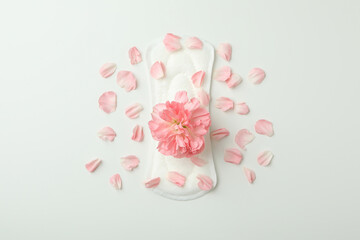 Hygiene pad with flower and petals on white background