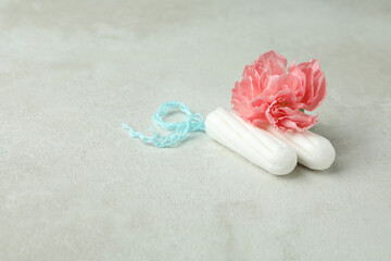 Tampons and flower on white textured background