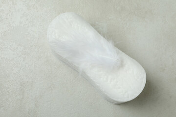 Stack of sanitary pads on white textured background