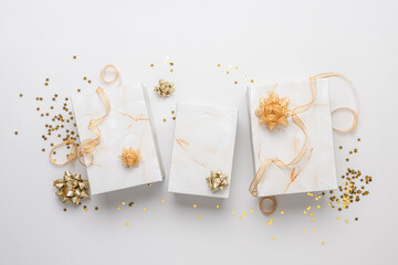 Gift boxes with gold ribbons and confetti on a white background. Banner size white festive background