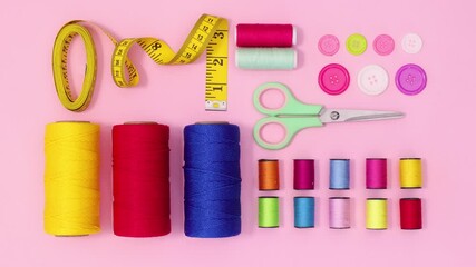 Knitting and sewing materials and items making creative layout on pastel pink background. Stop motion flat lay