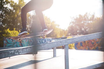 Skater is doing ollie on the ramp in a skatepark in sunny day