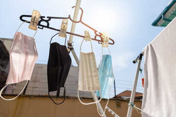 Surgical face mask hanging outside with sun light to get dried after washed. Reuse in outbreak of COVID-19