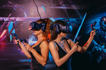 Virtual reality. Two women play games in a virtual reality helmet.