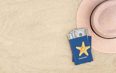 Beach hat and passports with money on sand. Copy space.