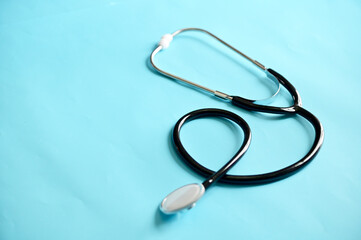 Black Stethoscope isolated on blue background in the nursing room at Thailand. Concept Medical and Health Care. Selective Focus.
