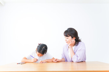 お家でお母さんとお勉強する女の子