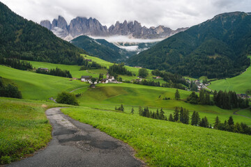 Fototapeta na wymiar Hiking trail to St Magdalena church in Val di Funes valley, Dolomites, Italy. Furchetta and Sass Rigais mountain peaks in background