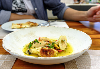 Dumplings Gyoza with crab filling served with mussels and microgreens, top view