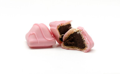 Closeup of bitten chocolate candy and whole one on the white background