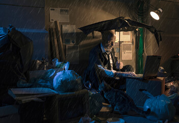 Broke jobless businessman sitting on the street under the rain