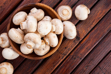 Mushrooms champignon on wooden background. Top view. Copy space.
