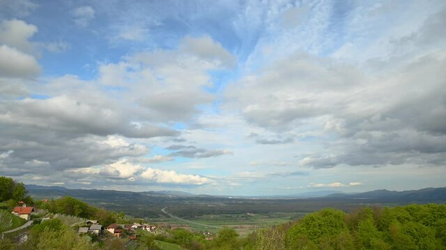 Time lapse of clouds moving over large basin in Slovenia. Wine fields in the foreground. Elevated view of beautiful landscape. Static shot, wide angle