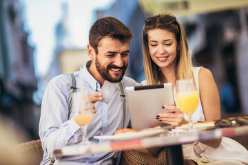 Young couple buying online with credit card and tablet in a coffee shop.