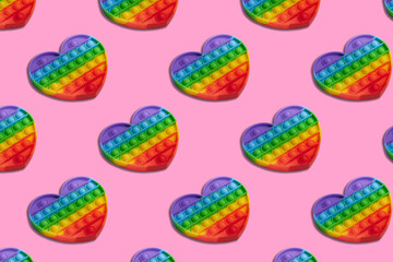 Rainbow heart shape isometric pattern of silicon toy for kids. Pop it fidget toy on pastel...