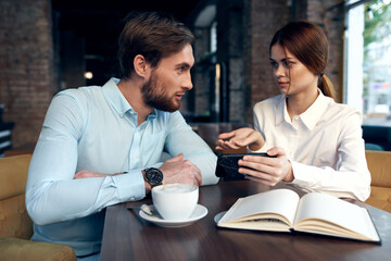 business man and woman look at the phone communication work colleagues