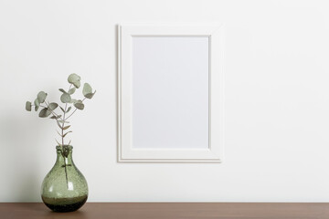 Fototapeta na wymiar Mock up empty white frame background. Empty frame for a photo or painting in a light Scandinavian minimalist interior on a white clean wall.