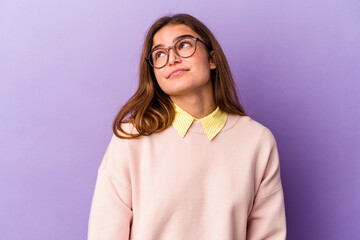 Obraz premium Young caucasian woman isolated on purple background dreaming of achieving goals and purposes