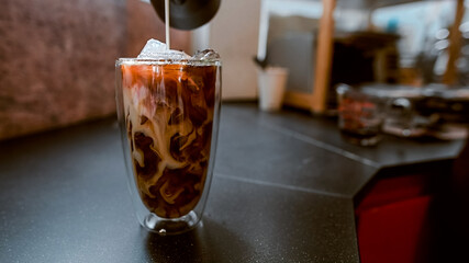 Close-up of iced coffee served on black table at cafe​