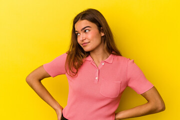 Young caucasian woman isolated on yellow background dreaming of achieving goals and purposes