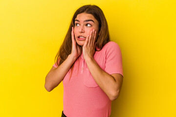Young caucasian woman isolated on yellow background scared and afraid.