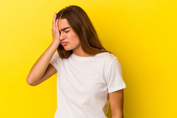 Young caucasian woman isolated on yellow background forgetting something, slapping forehead with palm and closing eyes.