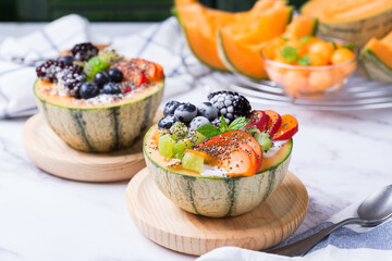 Fruit salad with yogurt in carved melon cantaloupe bowl