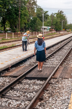 A girl is photographed dangerously on the train track in Hua Hin station, Thailand