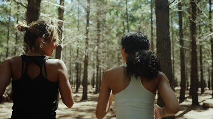 Mixed race friends keeping active while running through forest setting