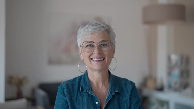portrait of a 55 year old smiling senior woman in her home
