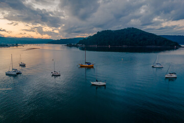 Fototapeta na wymiar Aerial sunrise waterscape with boats and cloud cover