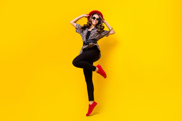 Fototapeta na wymiar Full body photo of happy nice pretty young woman wear red hat shoes smile isolated on shine yellow color background