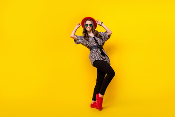 Fototapeta na wymiar Full size photo of charming happy attractive young woman wear red hat shoes isolated on yellow color background