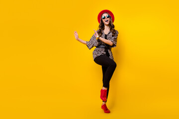 Fototapeta na wymiar Full body photo of charming happy nice young woman wear red hat shoes dance copyspace isolated on yellow color background