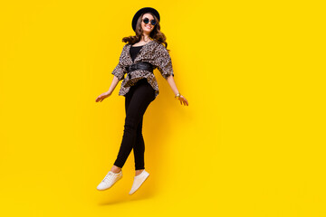 Obraz na płótnie Canvas Full length photo of cheerful funky young woman look empty space jump up isolated on yellow color background