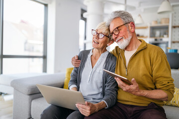 Fototapeta premium Senior couple websurfing on internet with laptop at home