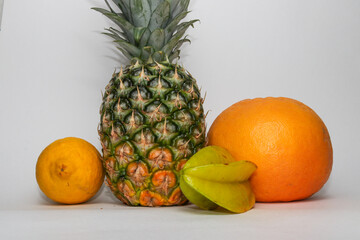 Still life of pineapple, lemon, carambola and grapefruit isolated on white