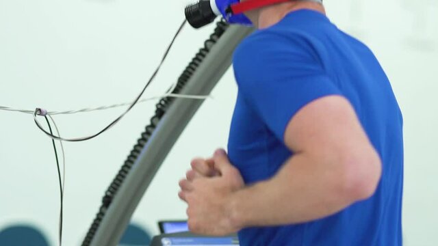 Man athlete going trough the Vo2 Max testing on treadmill in modern sport science lab. triathlete workout testing endurance preparing to the race. Professional sport analyzing