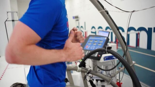Man athlete going trough the Vo2 Max testing on treadmill in modern sport science lab. triathlete workout testing endurance preparing to the race. Professional sport analyzing