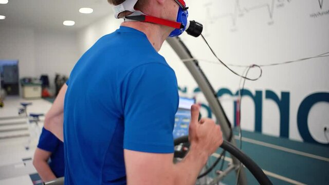 Man athlete going trough the Vo2 Max testing on treadmill in modern sport science lab. triathlete workout testing endurance preparing to the race. Professional sport analyzing