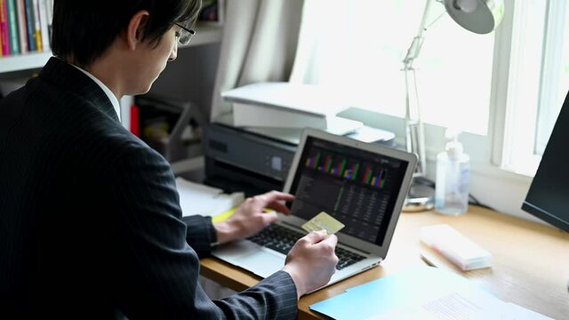 インターネットで株式市場をチェックする男性