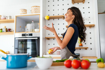 Young beautiful woman cooking healthy food in the kitchen. Healthy lifestyle, food, diet concept - obrazy, fototapety, plakaty