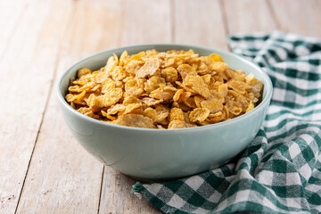Corn flakes in a blue bowl on wooden table 