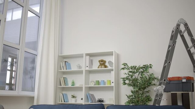 Young technician falling from ladder while working with ceiling, injury at work