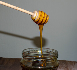 Wooden Honey Dipper Drizzling Honey