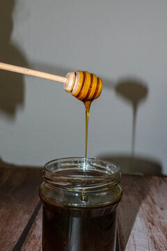 Wooden Honey Dipper Drizzling Honey
