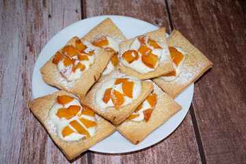 Sweet homemade bakery products with peach and curd cheese