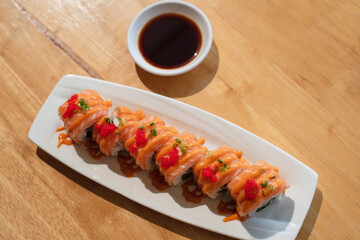 Spicy salmon sushi rolls in white plate
