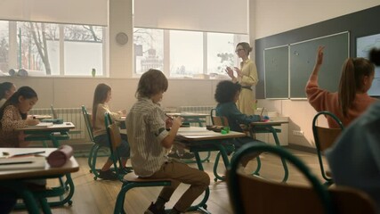 Teacher teaching students in classroom. Kids studying in auditorium at school - Powered by Adobe