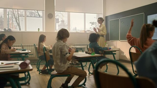 Teacher teaching students in classroom. Kids studying in auditorium at school